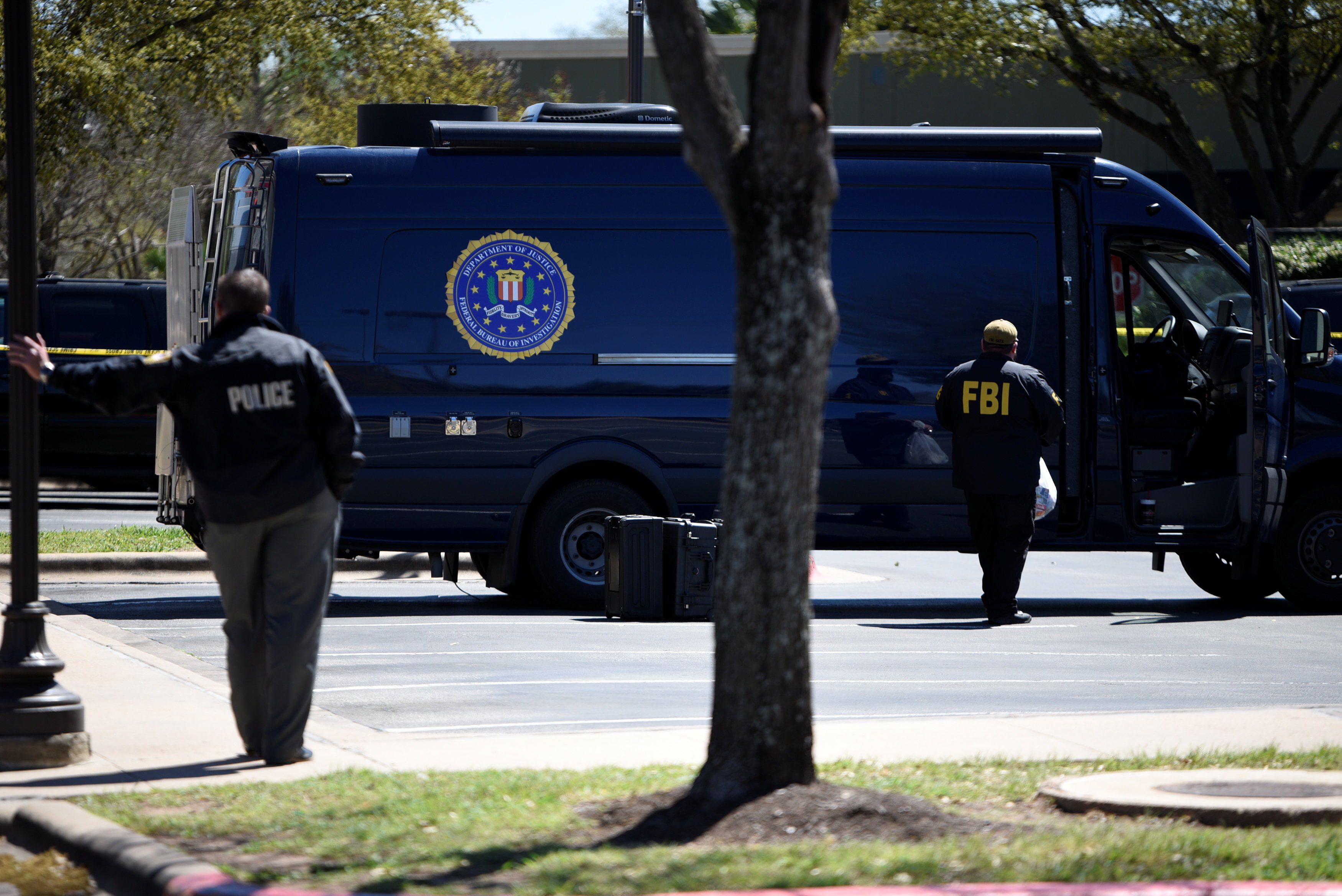 Law enforcement personnel are seen outside a FedEx Store which was closed for investigation, in Austin, Texas