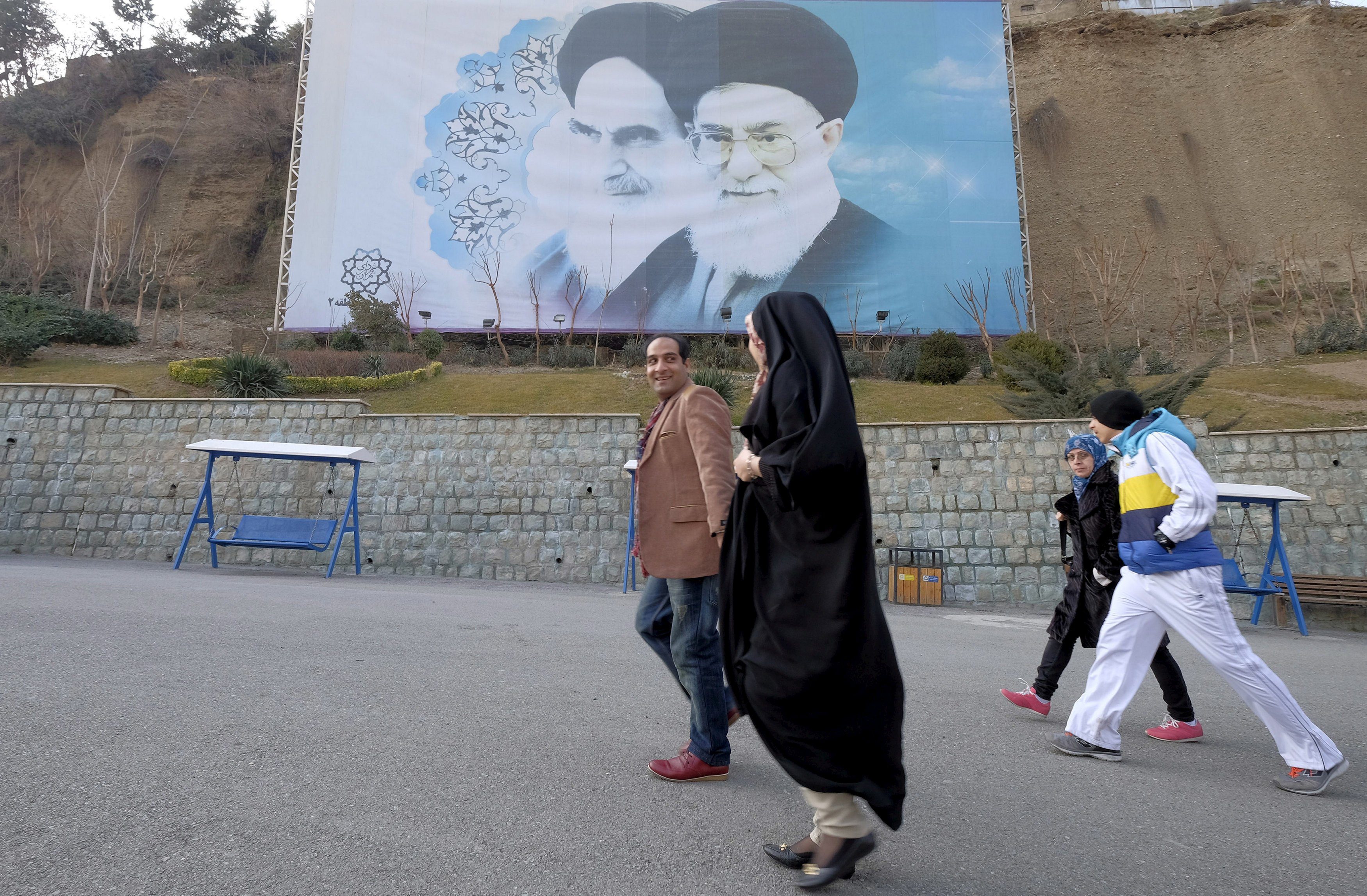 FILE PHOTO: Iranians walk past a large picture of Iran’s late leader Ayatollah Ruhollah Khomeini and Iran’s Supreme Leader Ayatollah Ali Khamenei at a park in Tehran