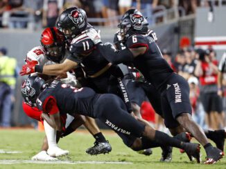 Texas Tech's Tahj Brooks (28) is tackled by North Carolina State's Aydan White (3), Payton Wilson (11), and Jakeen Harris (6) during the second half of an NCAA college football game in Raleigh, N.C., Saturday, Sept. 17, 2022.