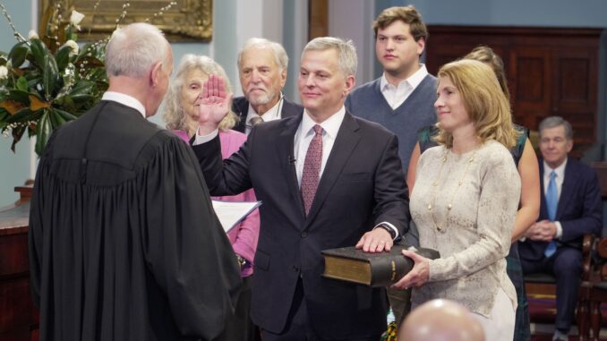 Josh Stein (D-N.C.), center, is sworn in as Governor of North Carolina on January 1, 2024, by N.C. Chief Justice Paul M. Newby (R-N.C.) at the State Capitol in Raleigh.